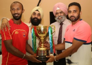 Joint Champions... Indian Oil captain Deepak Thakur (right) and South Central Railway skipper M.G. Poonacha (left) receive the Guru Tegh Bahadur Gold Cup from MHAL President, Mangha Singh Bakshi and Hon. Gen. Secretary, Ram Singh Rathor. 