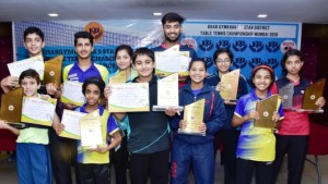 Men’s singles champ Ravindra Kotian (centre) and Vidhi Shah (women’s champ- with specs) with other winners of the Khar Gymkhana-5-Star Mumbai Suburban District table tennis championships .