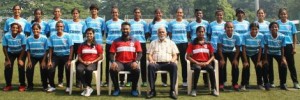 The players of the Maharashtra women team, coach Darryl Samuel, Manager Sana Shaikh, and Physiotherapist Sayali Shinde, pose before their departure to Kozhikode, Kerala to participate in the Senior Women's National Football Championship 2021-22. Also seen is WIFA Hon. Gen. Secretary, Souter Vaz (seated centre).